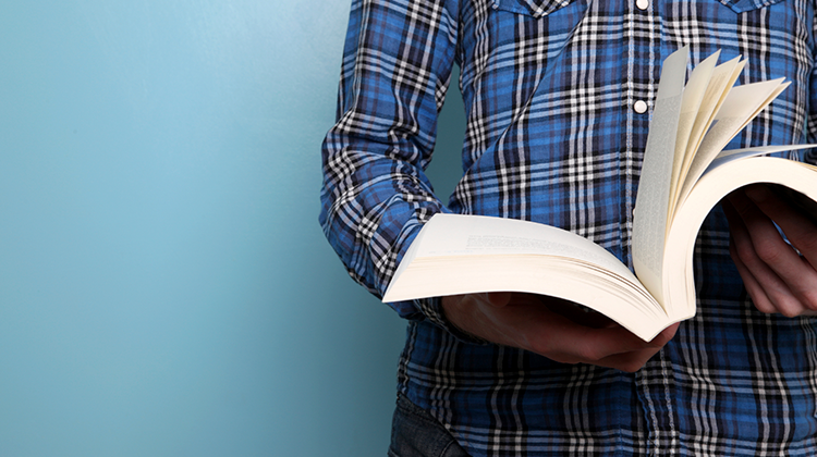 Person läser bok mot blå bakgrund