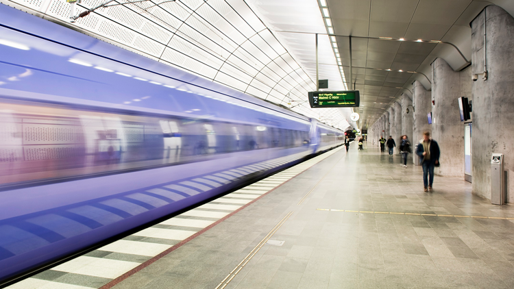 Tågstation med framrusande tåg